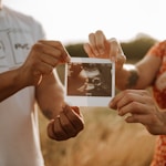 person holding a photo of a man and woman