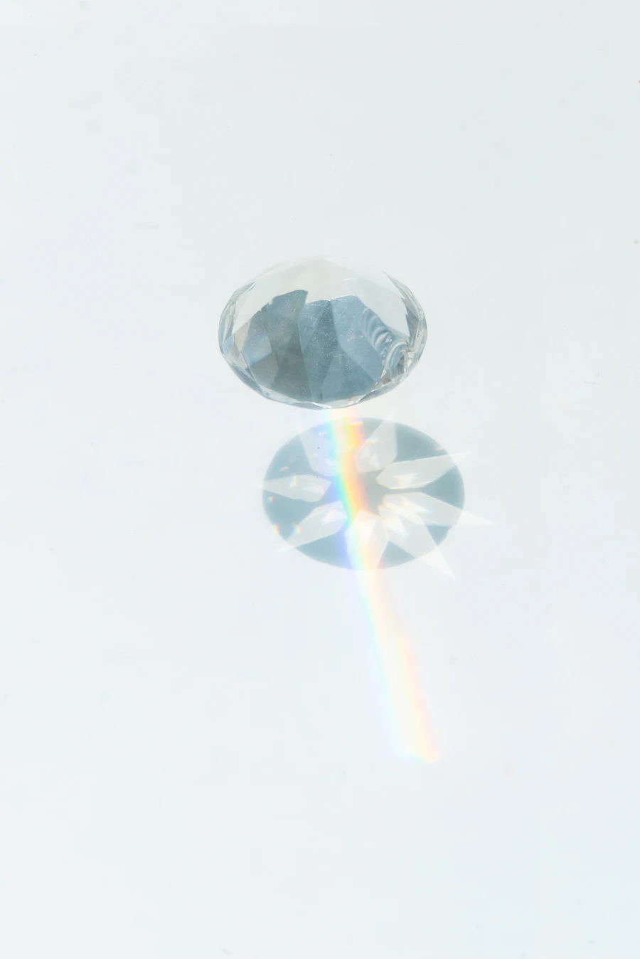 A clear glass sphere refracting light on a soft grey gradient