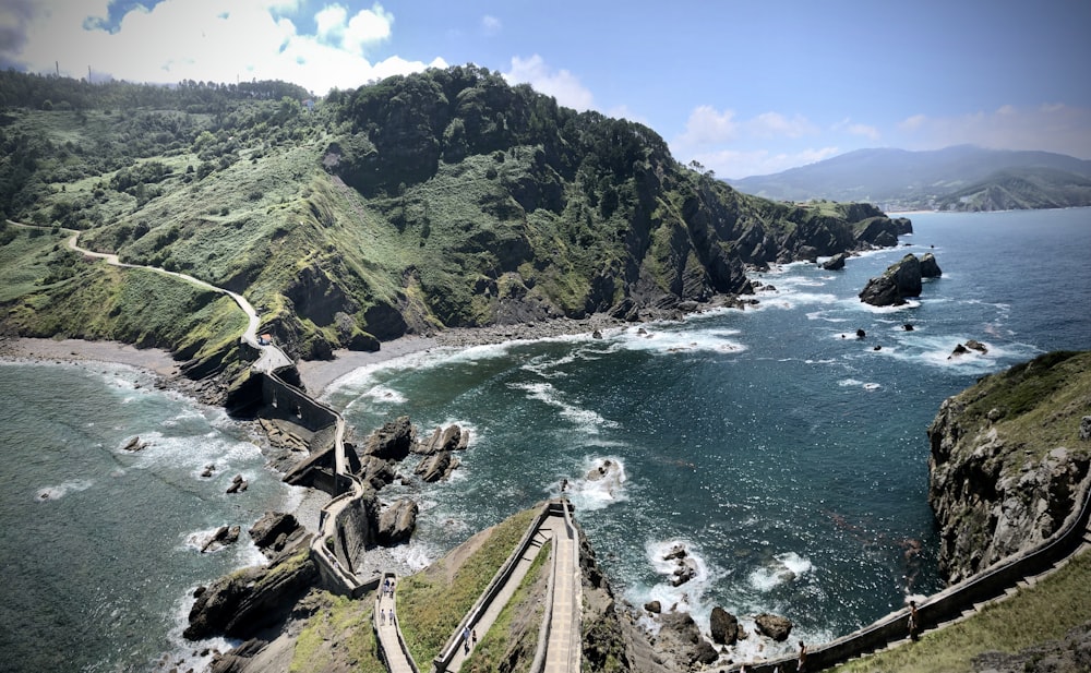 people walking on wooden pathway near sea during daytime