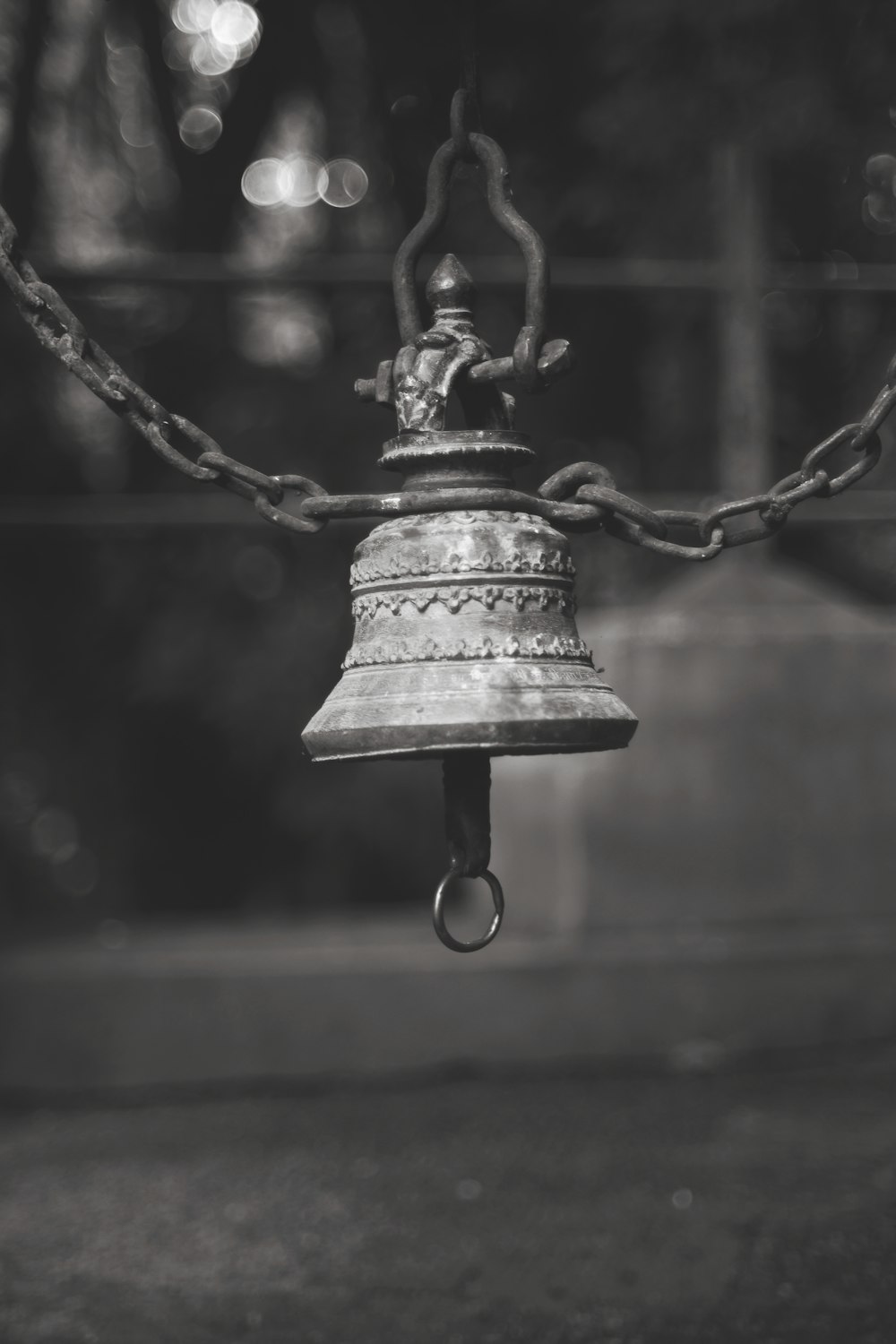 gray bell hanging on black metal wire