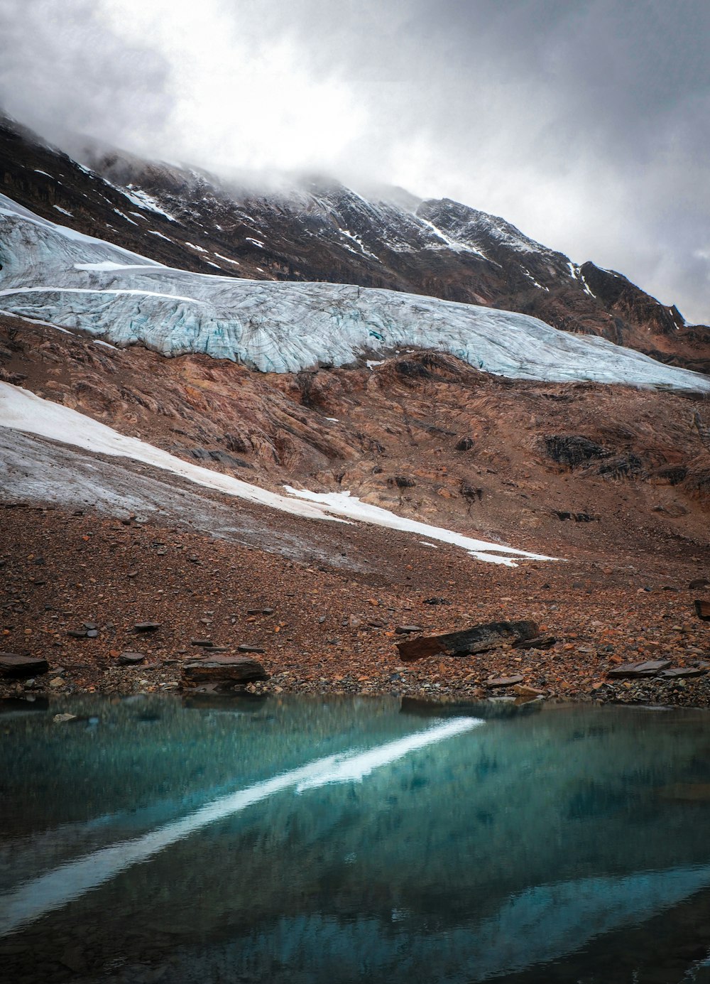 lake near snow covered mountain during daytime