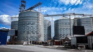 A modern agricultural silo base under construction on a clear day.