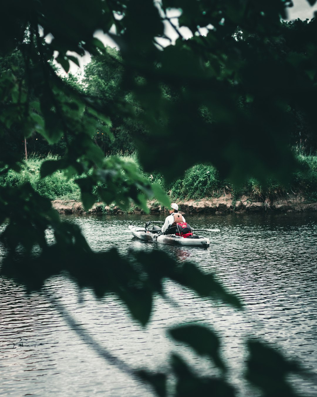 man in red shirt riding on red kayak on river during daytime