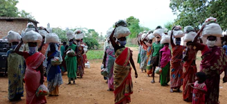 A team of community health workers walking through a neighborhood, carrying medical supplies
