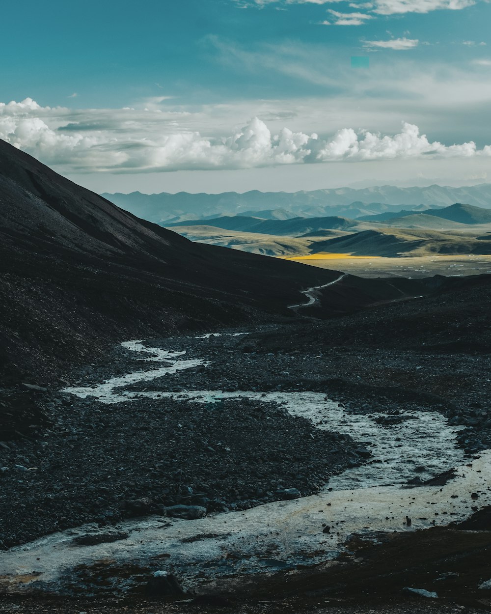 black and white mountains under white clouds and blue sky during daytime