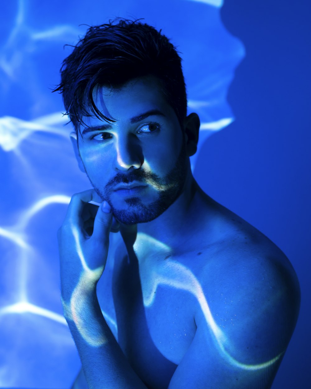 topless man with blue and white paint on face