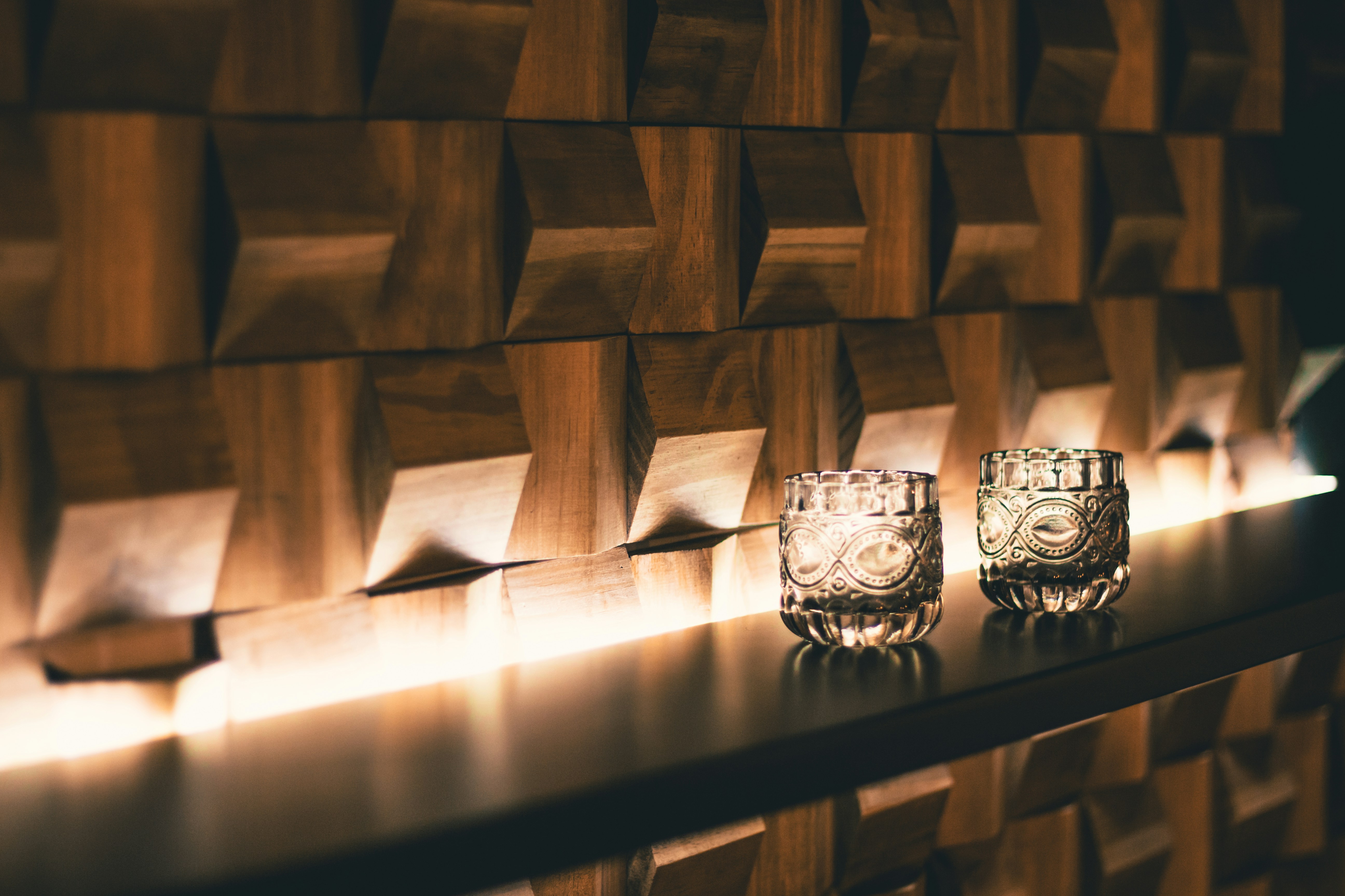 Glasses on a lit timber shelf