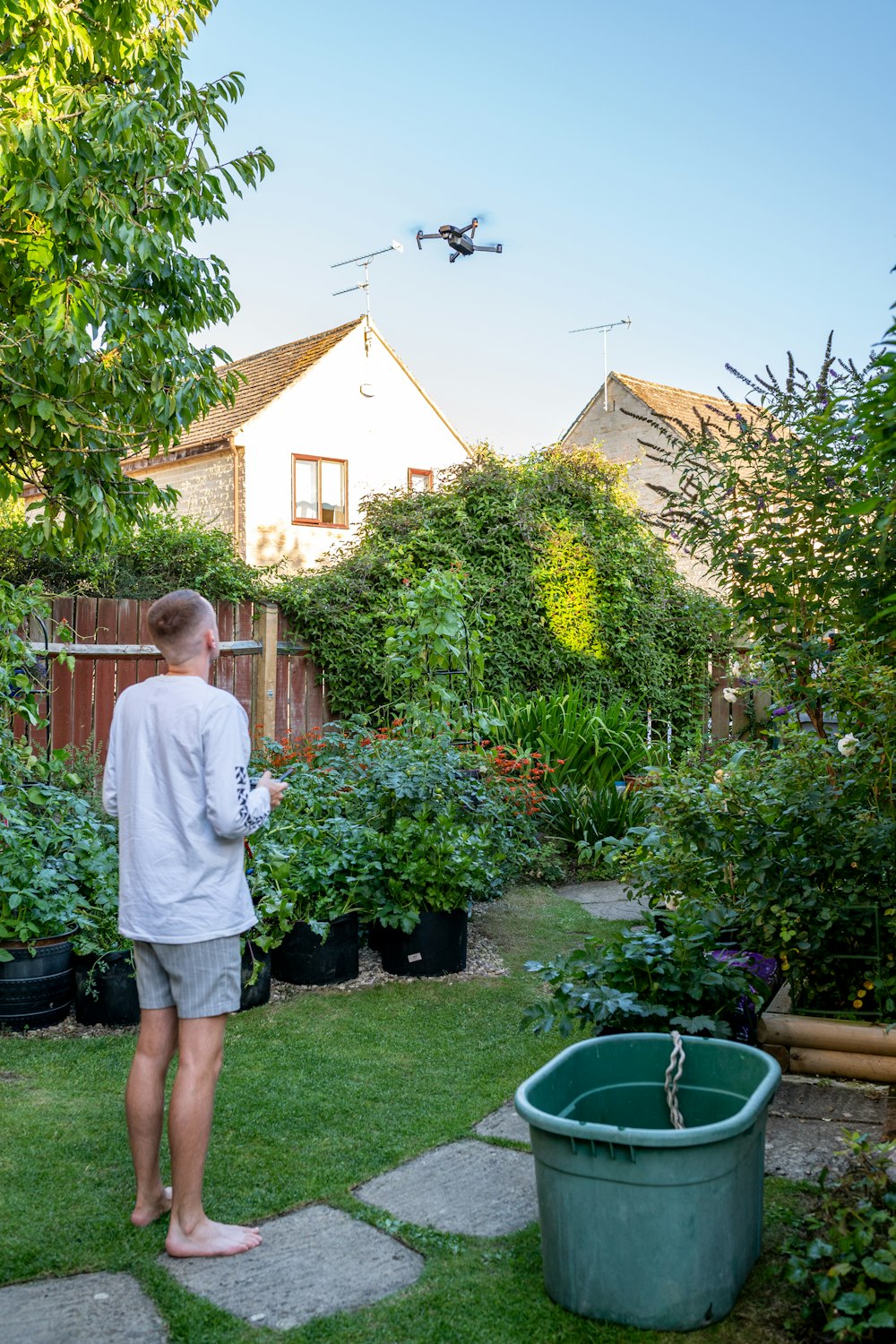 man in white dress shirt and gray shorts standing near green trees during daytime