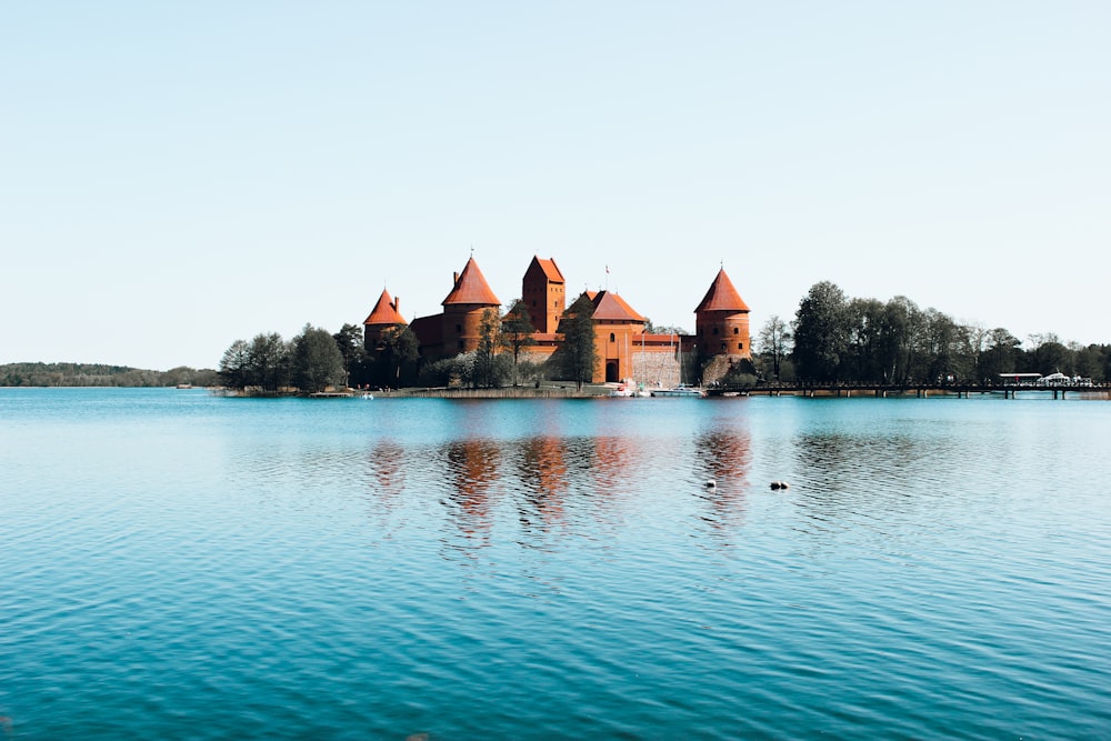 brown concrete building beside body of water during daytime