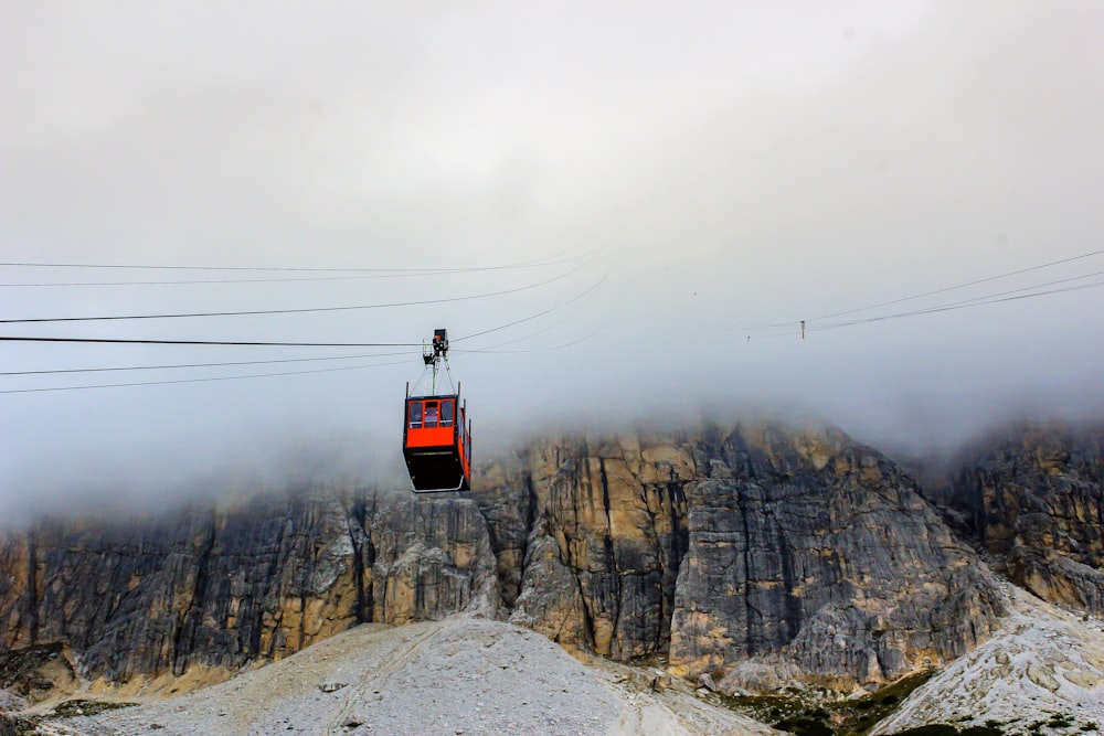 red cable car over snow covered mountain