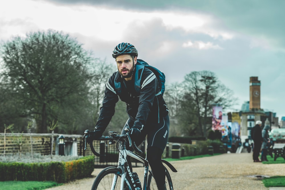 man in black jacket riding bicycle during daytime