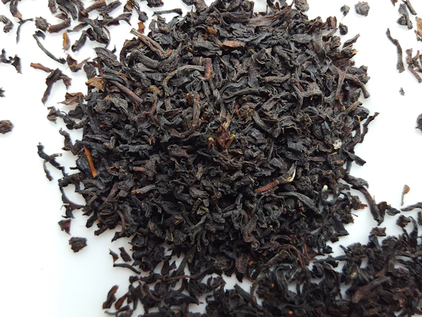 Delicate orthodox black tea leaves spread gracefully on a rustic surface