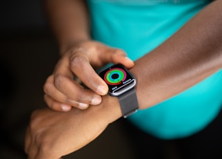 person wearing silver aluminum case apple watch with white sport band