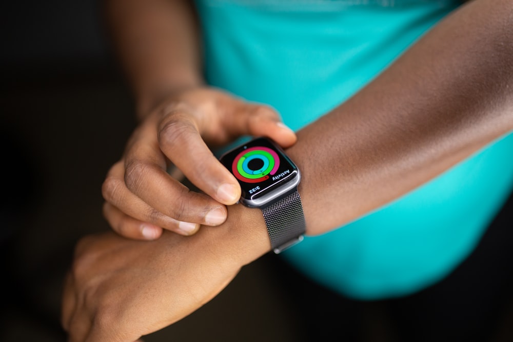 person wearing silver aluminum case apple watch with white sport band