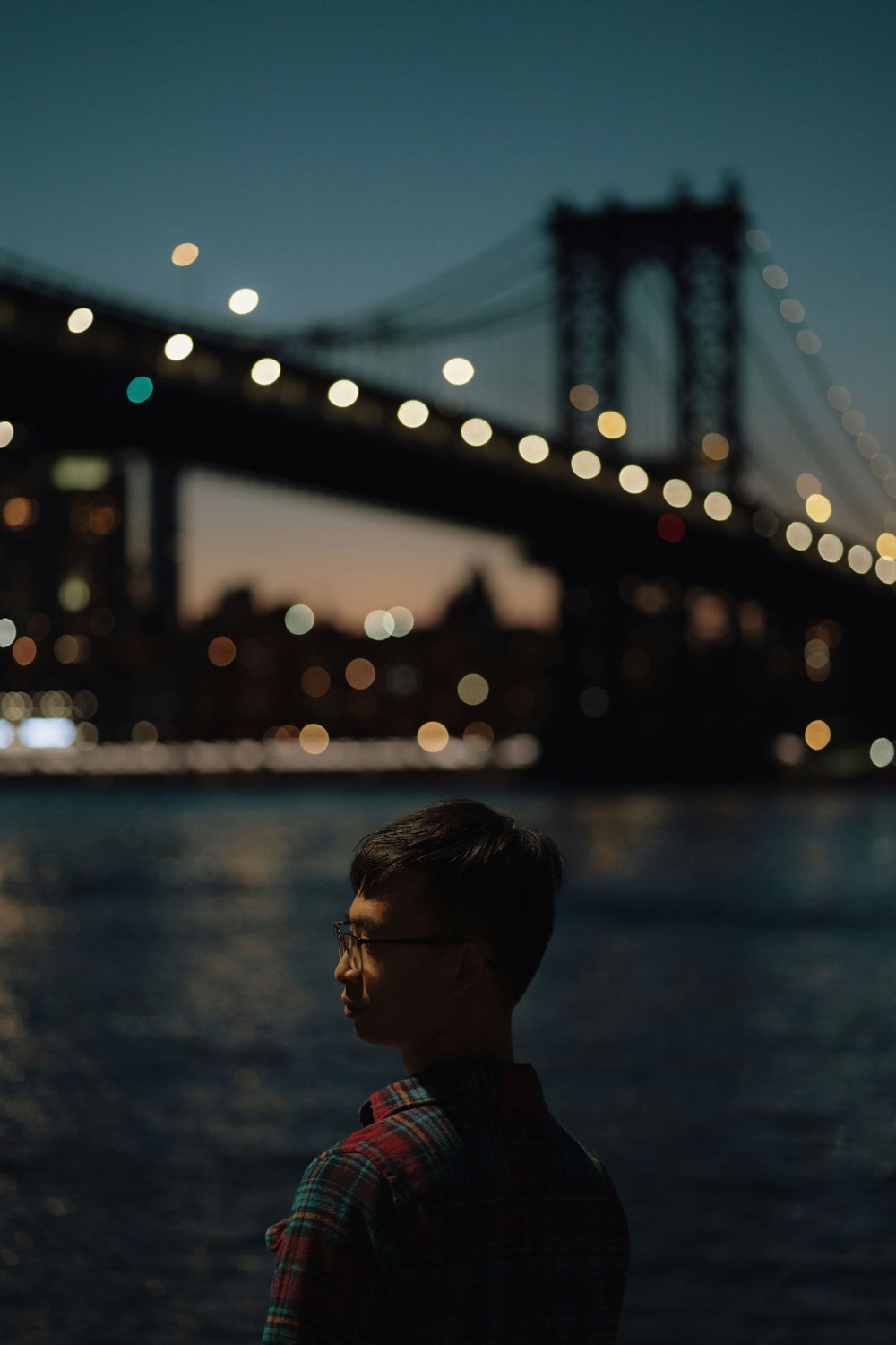 girl in pink shirt standing near body of water during night time