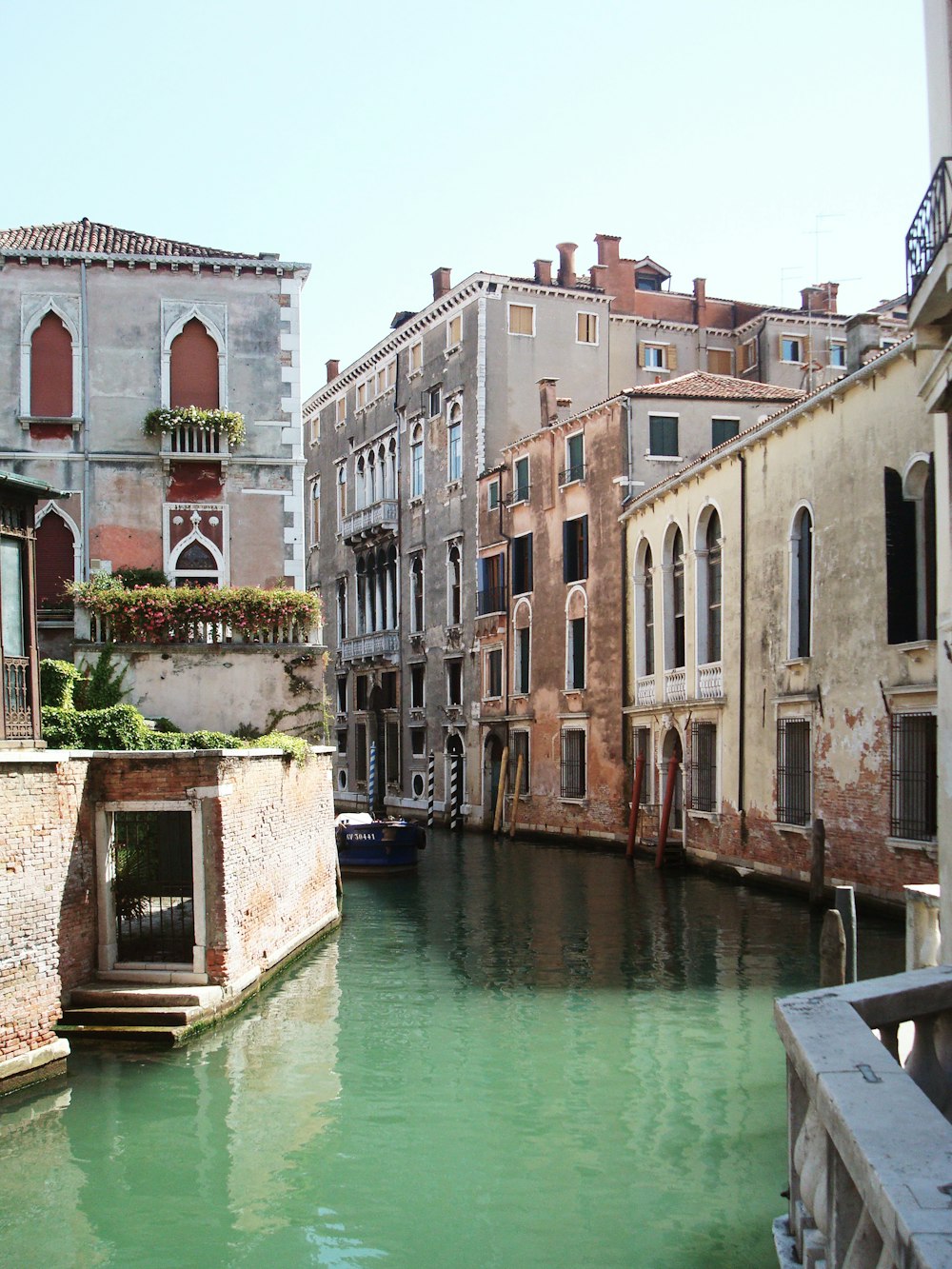 white boat on river between concrete buildings during daytime