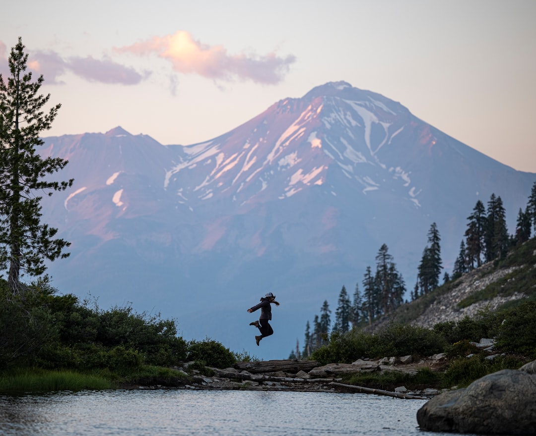 person standing on rock near lake during daytime