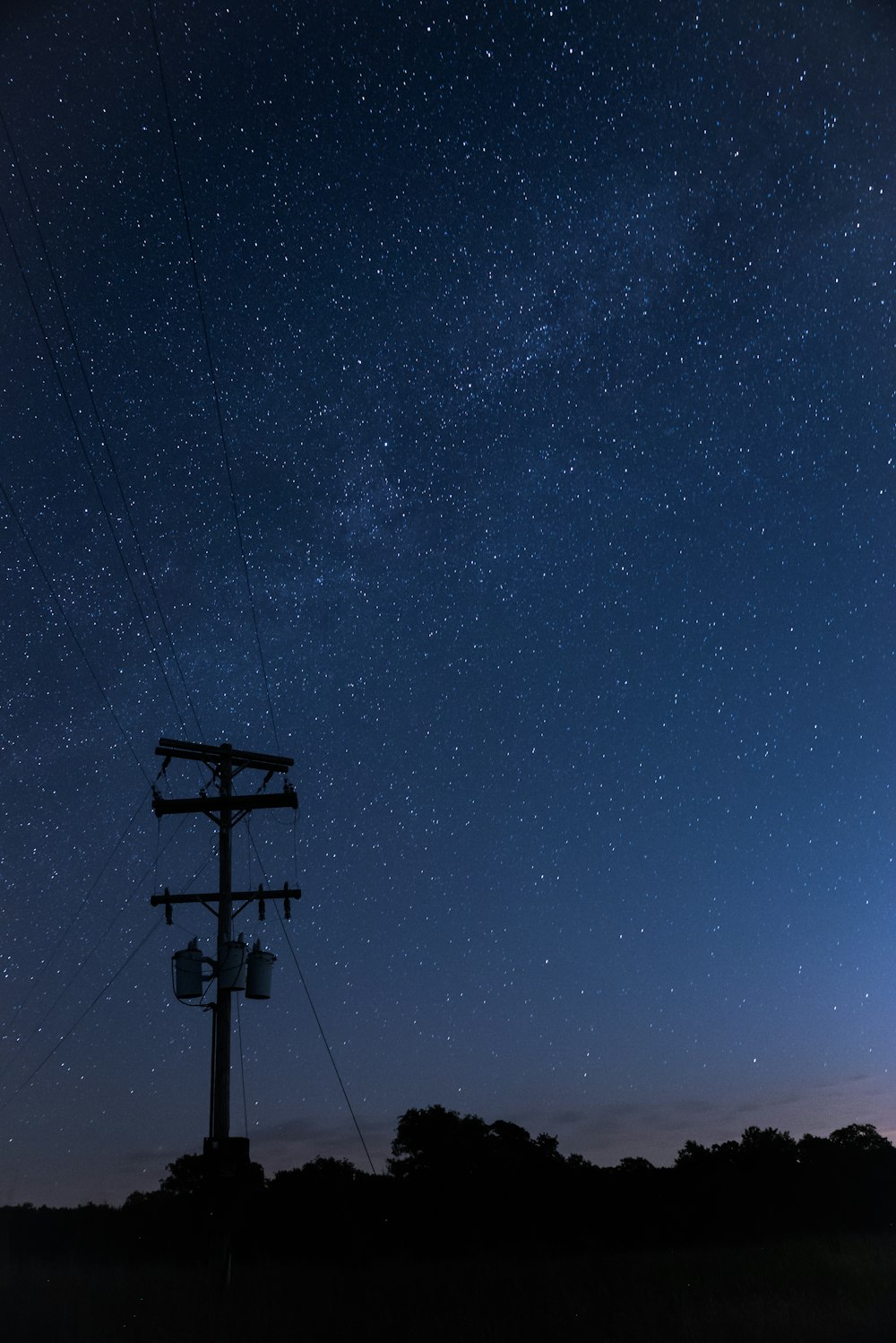 Schwarze Straßenlaterne unter blauem Himmel während der Nacht