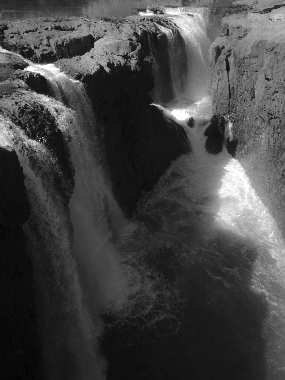 grayscale photo of man in water falls