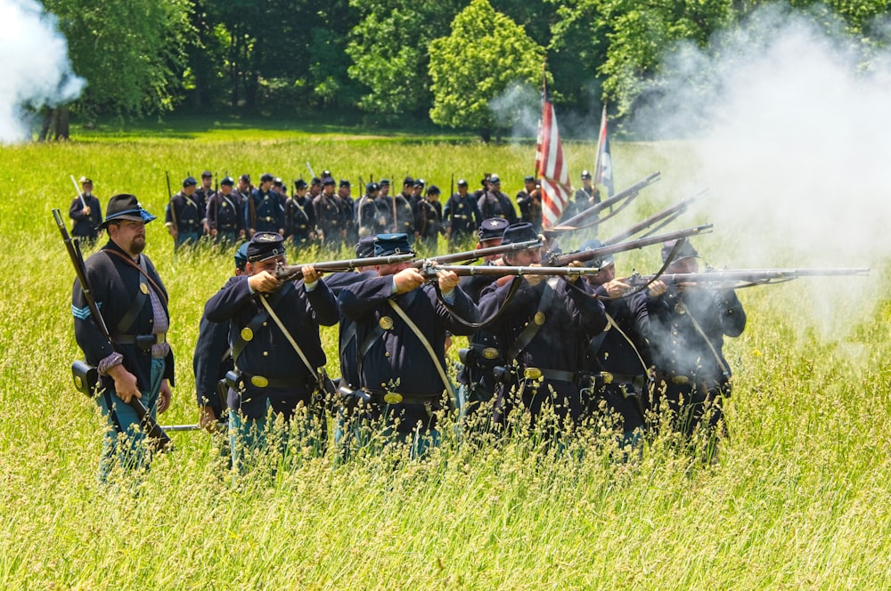 pessoas em uniforme preto em pé no campo de grama verde durante o dia