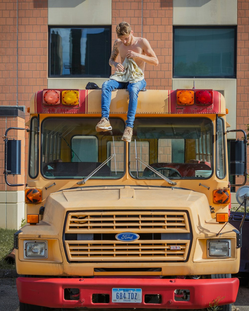 woman in blue denim jeans and white boots standing beside yellow school bus during daytime