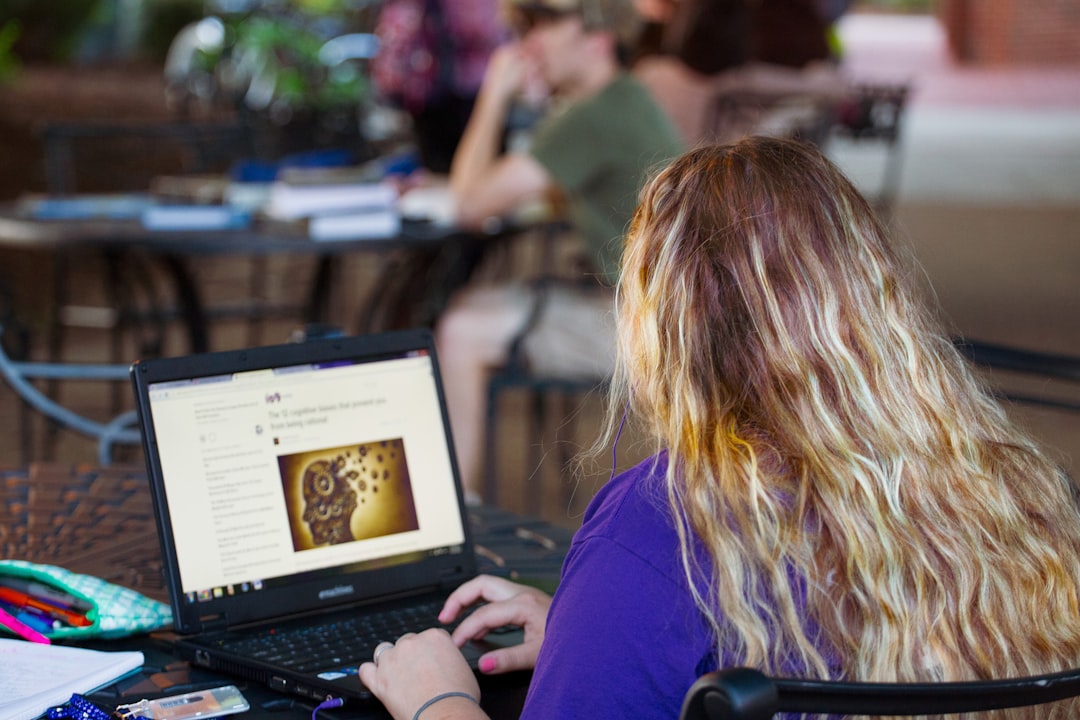 woman in purple shirt using black laptop computer