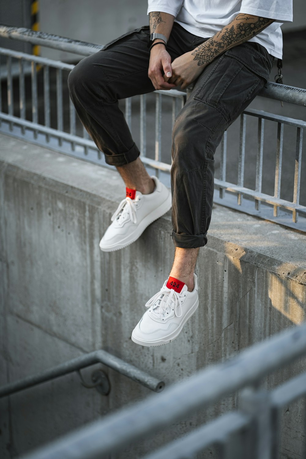 person in black pants and white nike sneakers