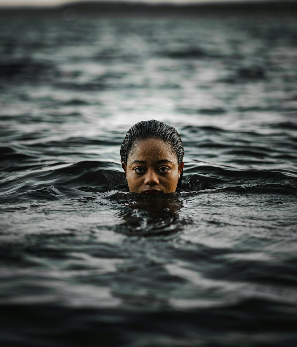 boy swimming in water during daytime