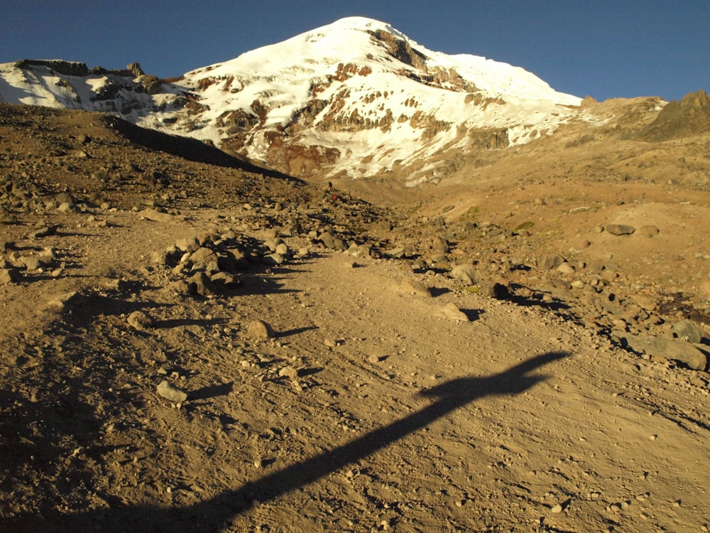 brown soil near snow covered mountain during daytime