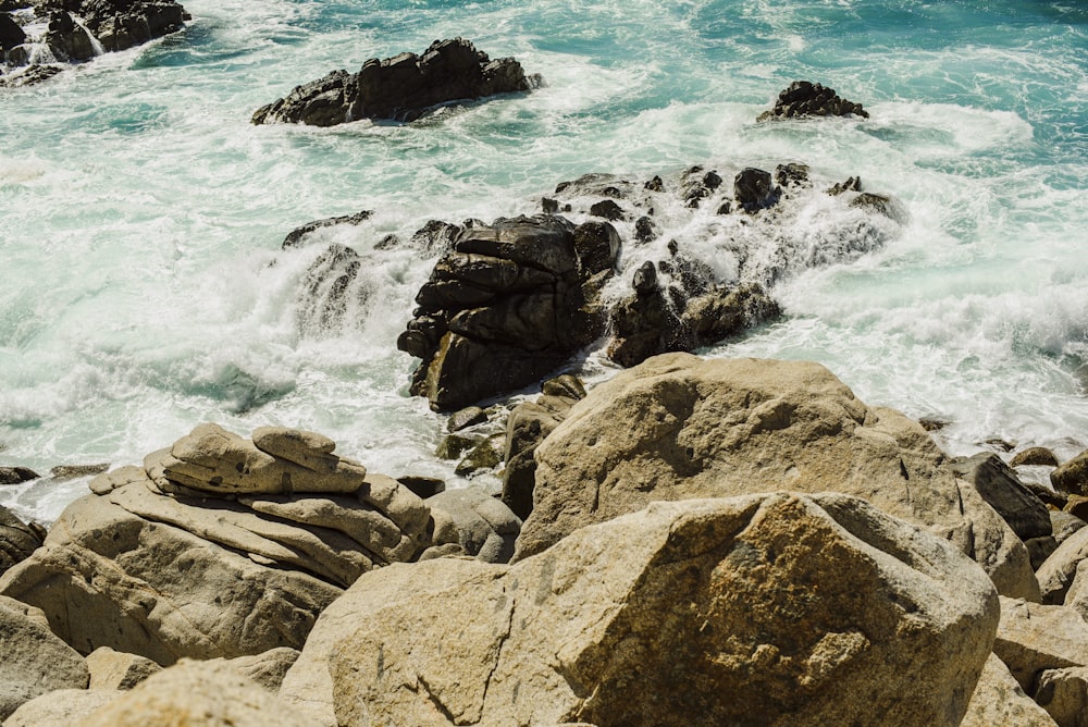 brown rocky shore with ocean waves during daytime