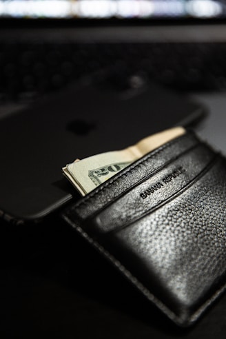 black leather bifold wallet with cash visible