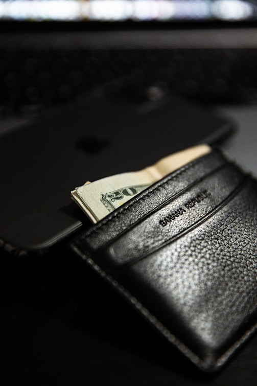 black leather bifold wallet with cash visible