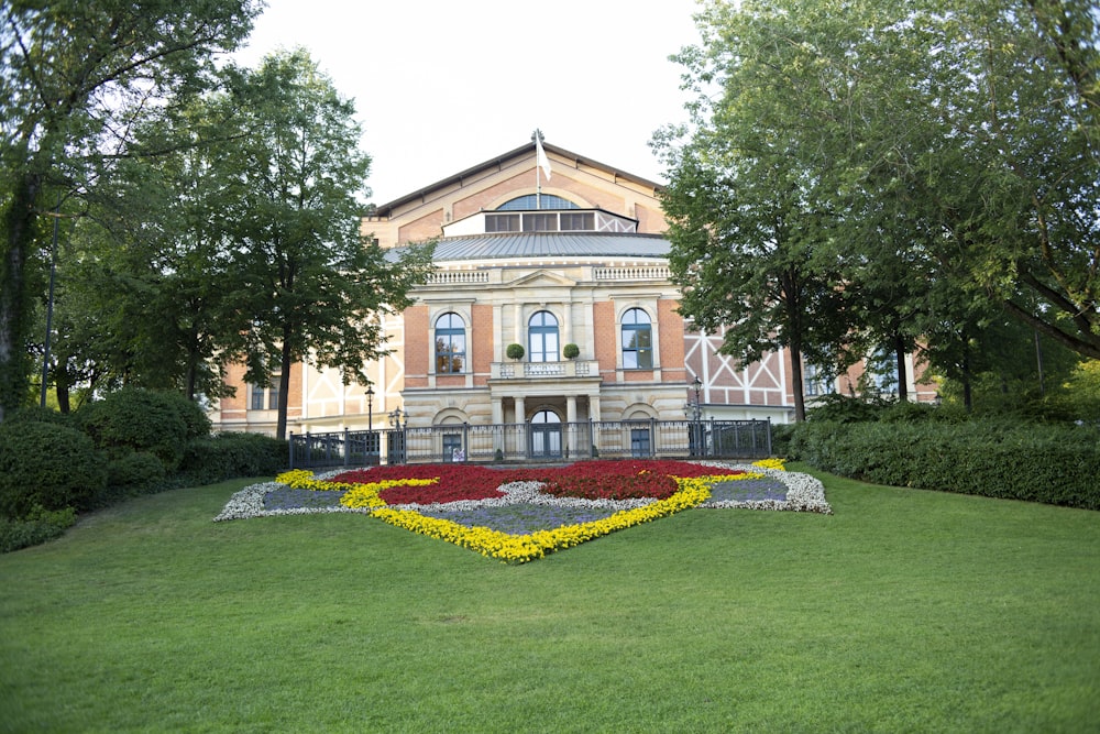 Grüner Rasen in der Nähe von braunem und weißem Betongebäude tagsüber