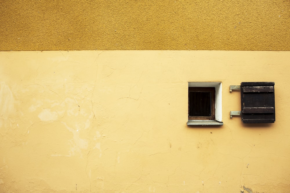 white window on yellow painted wall