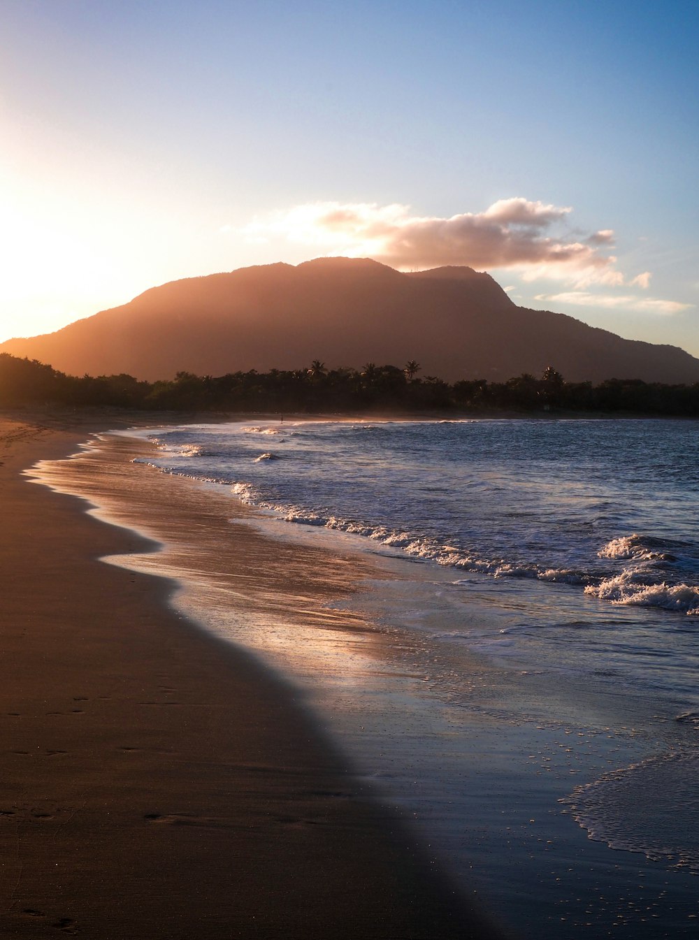 sea waves crashing on shore during sunset