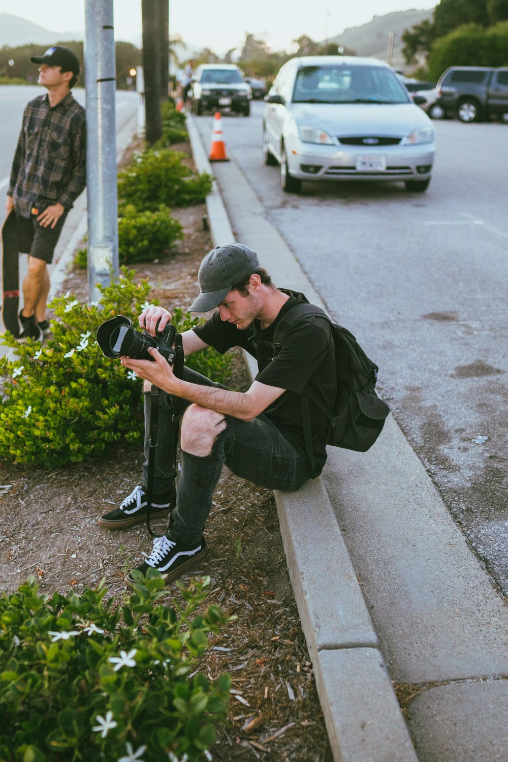 man in black t-shirt and black pants holding black dslr camera