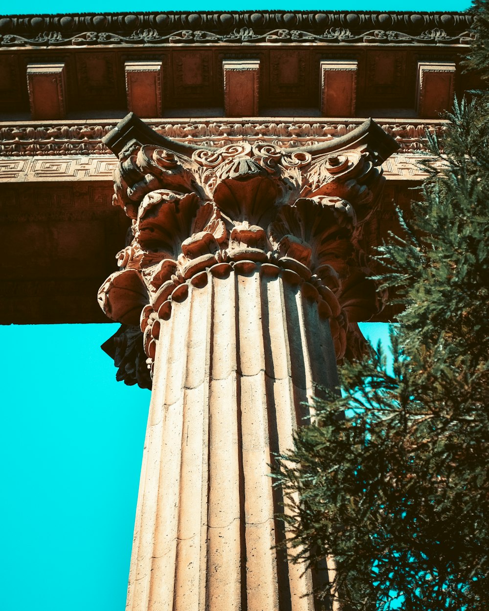 brown concrete statue near green trees during daytime