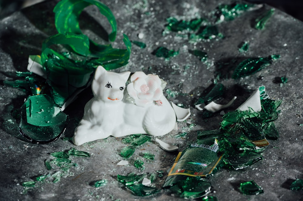 white cat figurine on green moss