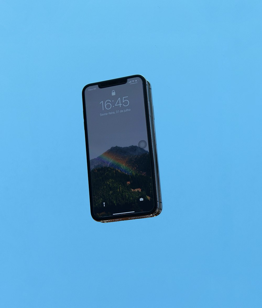 Schwarzes iPhone 4 auf blauer Oberfläche