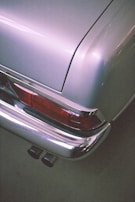 A shiny rear bumper fitted perfectly on a modern car, reflecting the workshop lights.