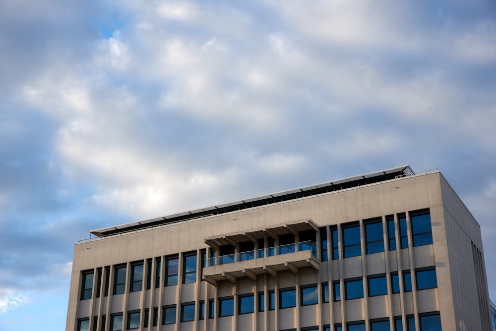 Weißes Betongebäude unter blauem Himmel tagsüber