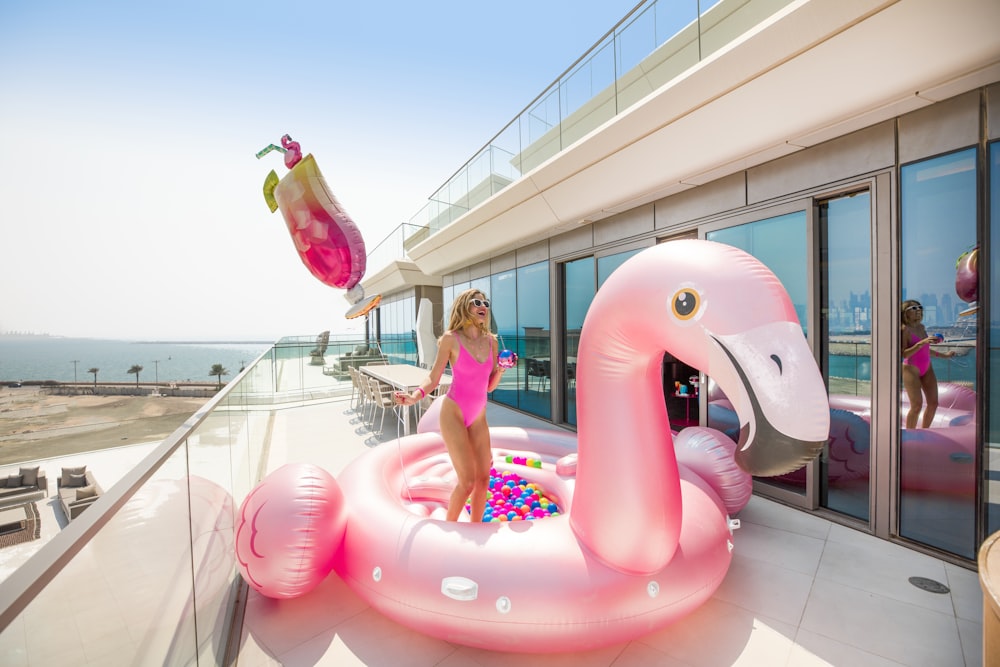 woman in pink dress sitting on pink inflatable ring