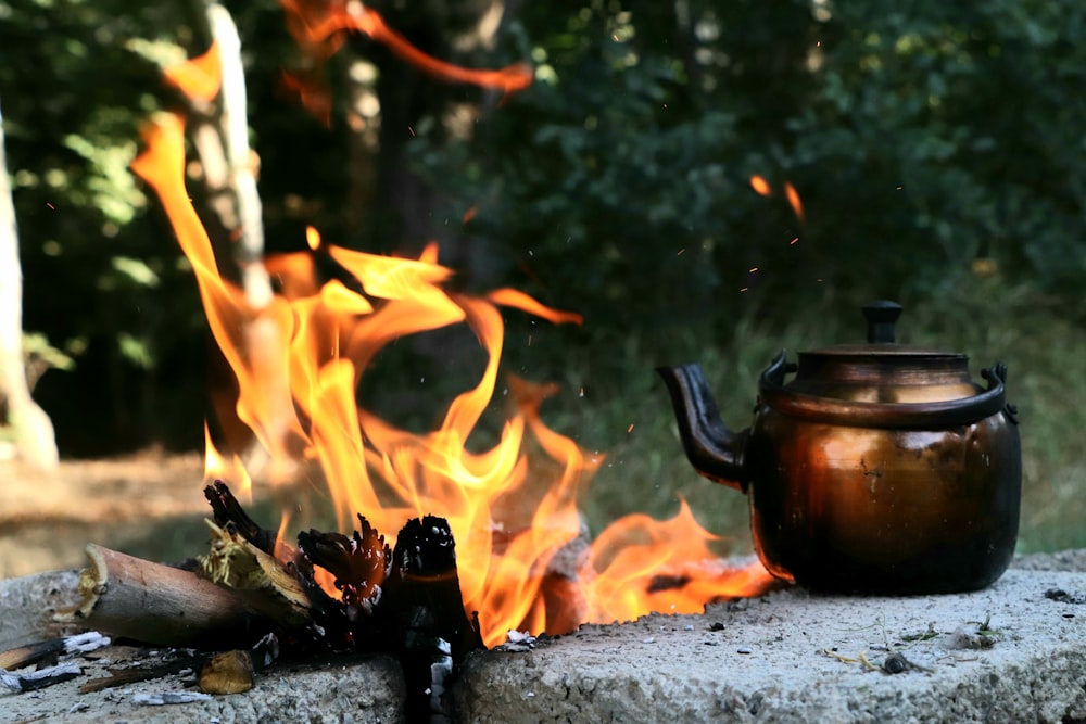 brown ceramic teapot on fire