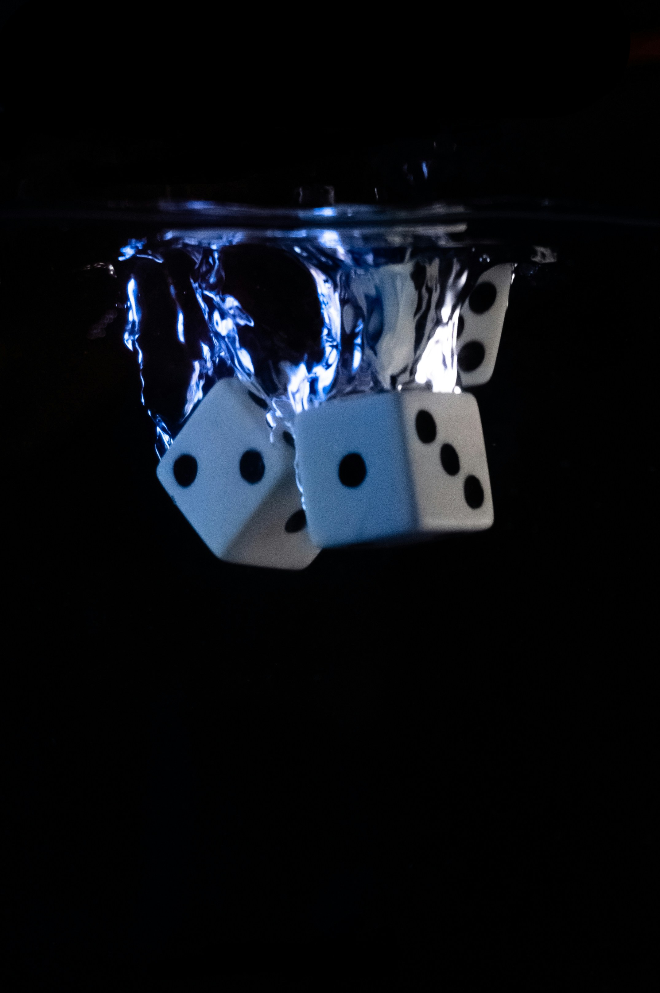 white and black dice in blue and white container