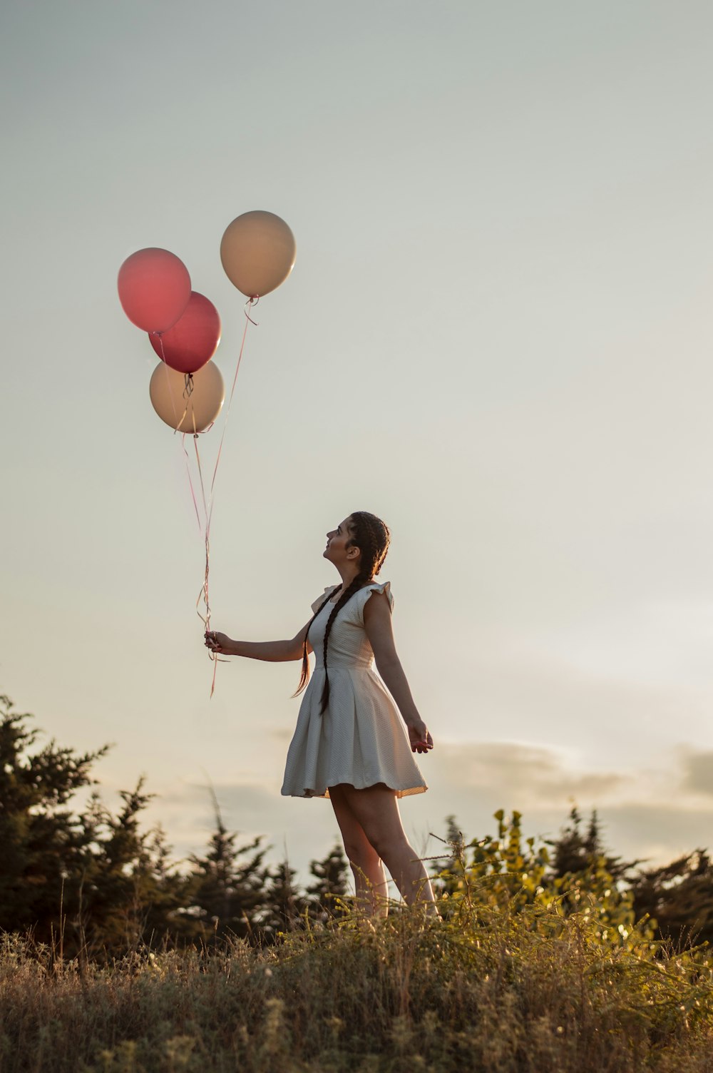 woman in blue and white dress holding balloons
