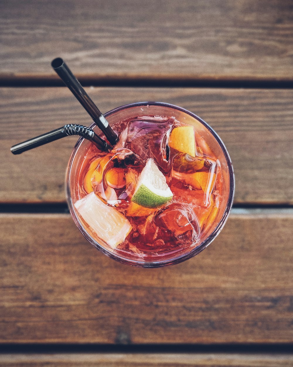 clear drinking glass with red liquid and ice cubes