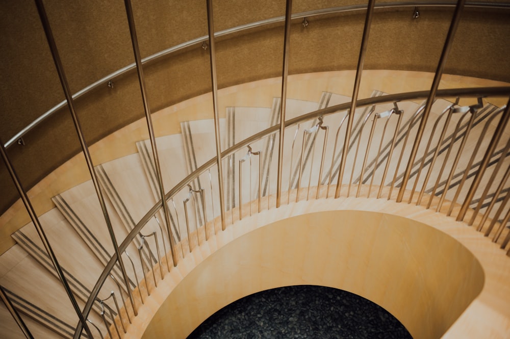 brown wooden spiral staircase with black round rug