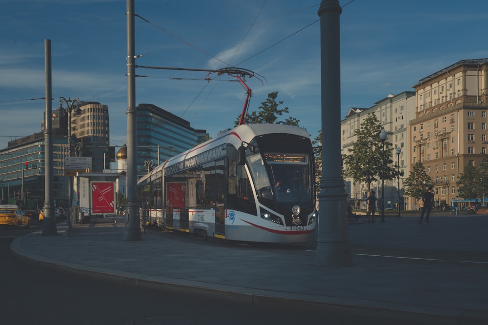 red and white tram on road during night time