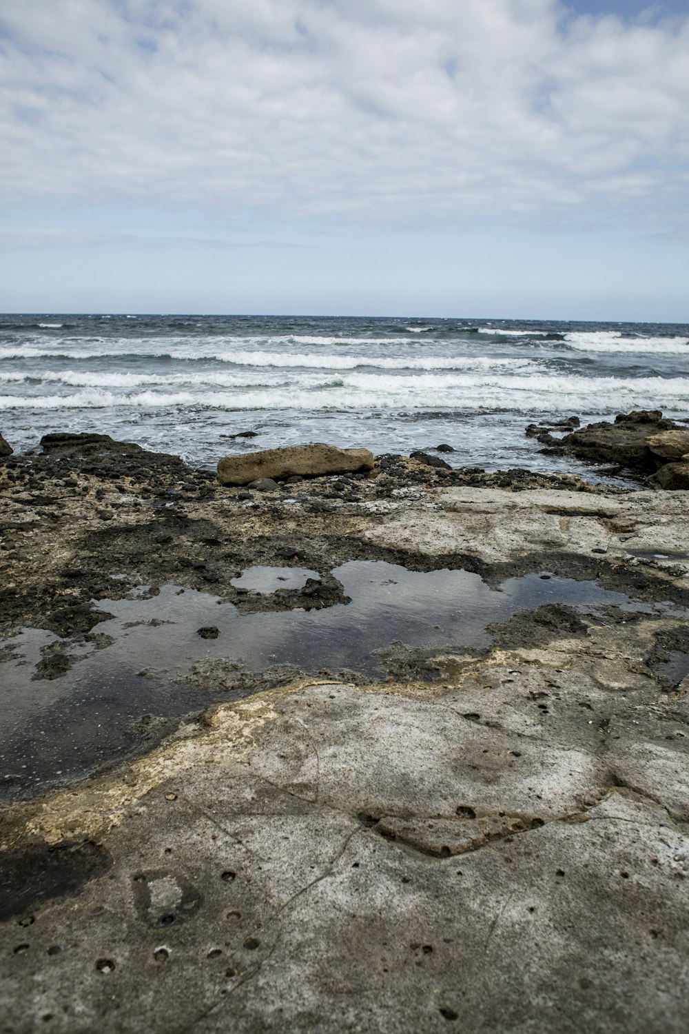 brown rocky shore under blue sky during daytime