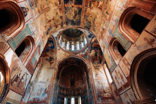 low angle photography of brown concrete building in Gelati Monastery Georgia